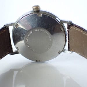 Vintage Swiss-made wristwatch with stainless steel case and worn leather strap.