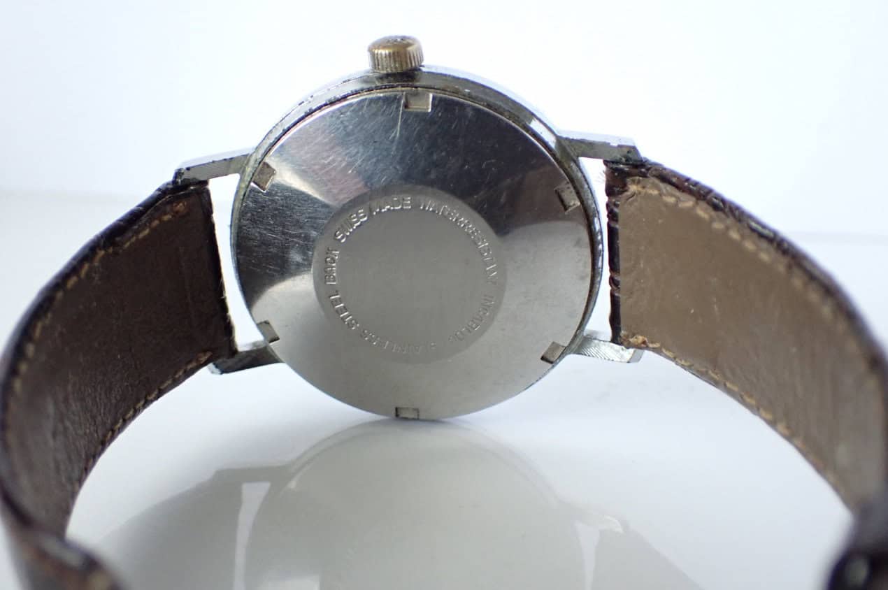 Vintage Swiss-made wristwatch with stainless steel case and worn leather strap.