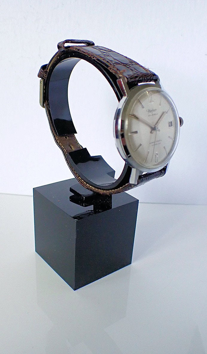 Elegant vintage Hamilton wristwatch with leather strap on display stand.