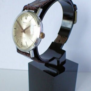 Quartz vintage wristwatch with leather strap on display stand.