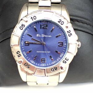 The Ben Sherman Men's Blue Dial Silver Colour Bracelet Watch features a silver metal strap, blue dial with silver hour markers and hands, minute-marked bezel in five-minute increments, and is displayed on a black cushion.