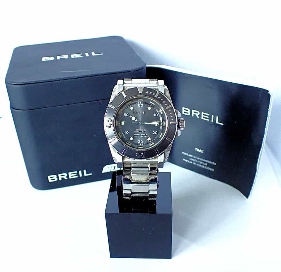 A Breil Manta Diver TW0734 wristwatch is shown on a black stand with its branded box and paperwork, all set against a white background.