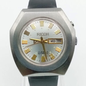 The Ricoh Automatic Japan Men's Day/Date Watch features a metallic case, white dial with gold Roman numerals and hands, day/date display, and a black leather strap.
