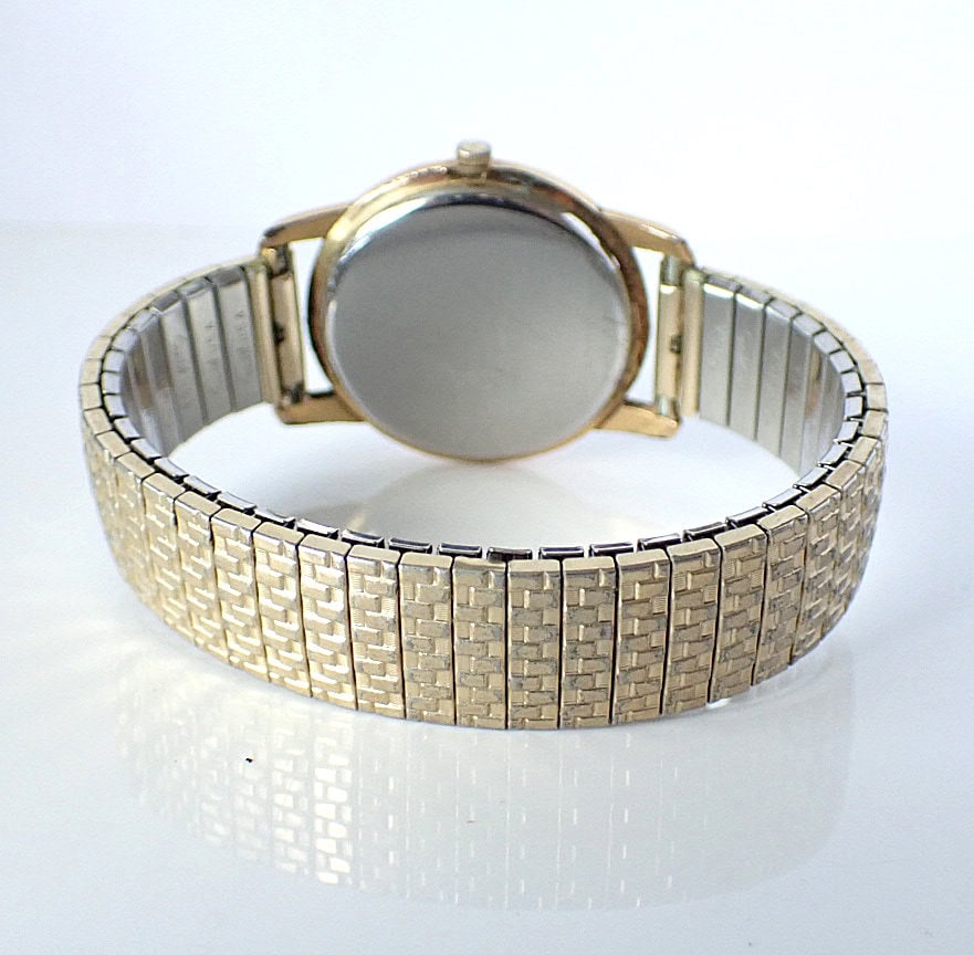 Vintage gold-tone watch with metal bracelet, back view showcasing elegant design.