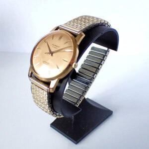 Stainless steel and gold vintage watch with a minimalist dial on display stand.