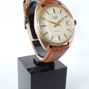 Vintage gold-tone wristwatch with cream dial and brown leather strap, Swiss made, classic automatic timepiece.