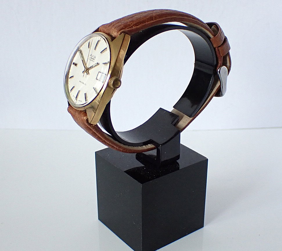 Vintage Seiko wristwatch with leather strap on display stand, classic men's watch design.