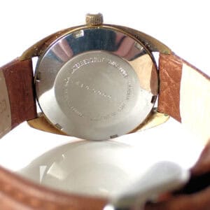 Stainless steel back of vintage Citizen watch with leather strap close-up.