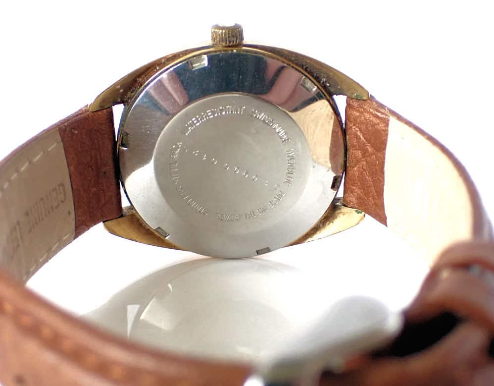Stainless steel back of vintage Citizen watch with leather strap close-up.