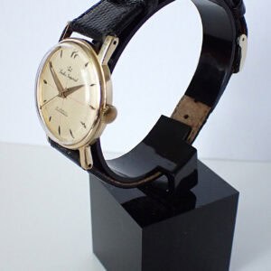 Vintage gold wristwatch with leather strap on display at The Watchaholic.