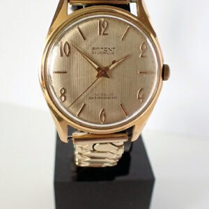 Stainless steel vintage wristwatch with gold-tone case and classic design.