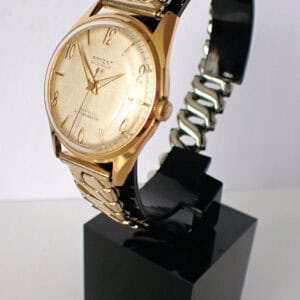 Gold-tone vintage wristwatch with metal bracelet and textured dial, stylish men's design.