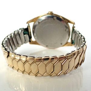 Stainless steel and gold-tone wristwatch with expandable bracelet, stylish accessories.