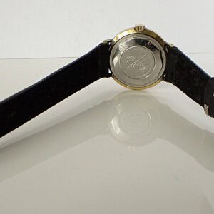 Leather strap wristwatch with metal case back and branding details.