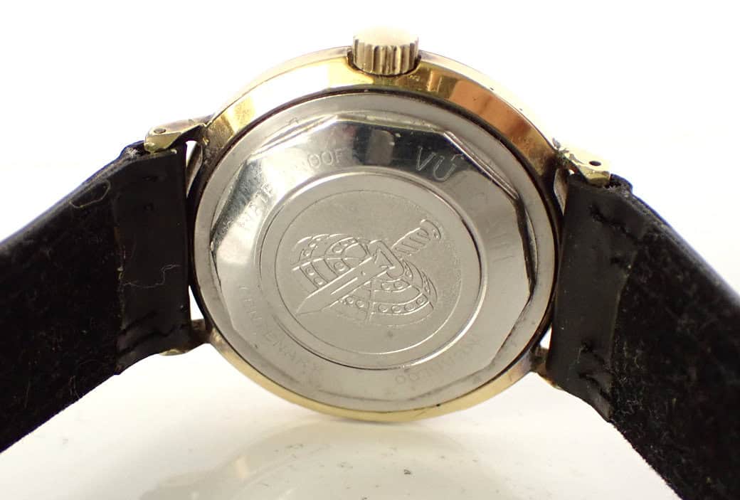 Stainless steel case back of vintage wristwatch with engraved logo and black leather strap, classic men's watch accessory.