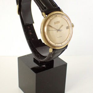 Vintage Vulcain automatic wristwatch with leather strap on display stand.