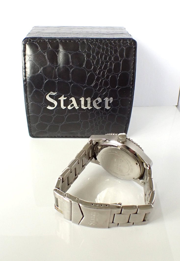Stauer wristwatch with a stainless steel band and black textured box.