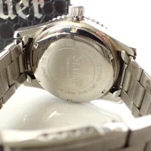 Stainless steel watch back with engraved details and metal link bracelet close-up.