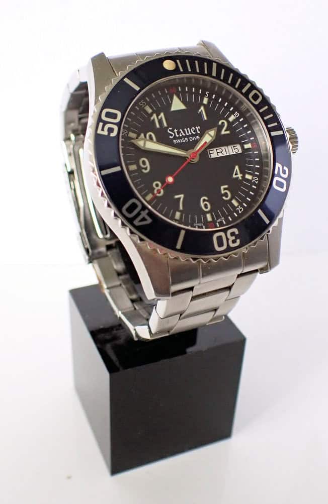 Stauer Swiss Dive watch on display with black bezel and stainless steel bracelet.