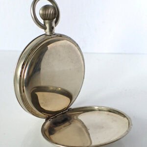Vintage silver pocket watch in open case, classic travel accessory.