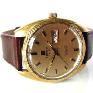 A vintage Tissot Seastar Day Date Automatic c1975 wristwatch features a gold-tone round case, brown leather strap, and a gold dial with day-date display showing WED 25.