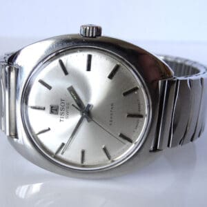 A Tissot Seastar Manual Wind Jumbo 1972 wristwatch with a round dial, silver hour markers, and matching metal strap is displayed on a white surface.