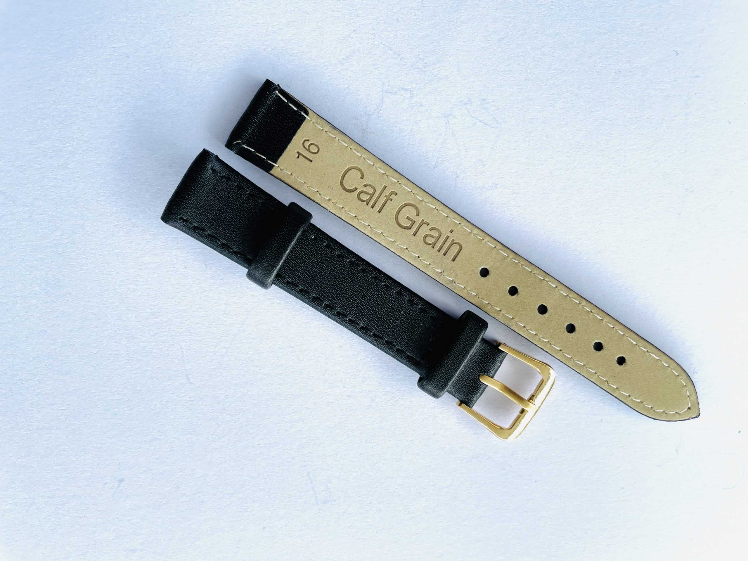 A Genuine Leather Watch Strap 16mm in black with a gold coloured buckle, showing the underside labelled "Calf Grain" against a white background.