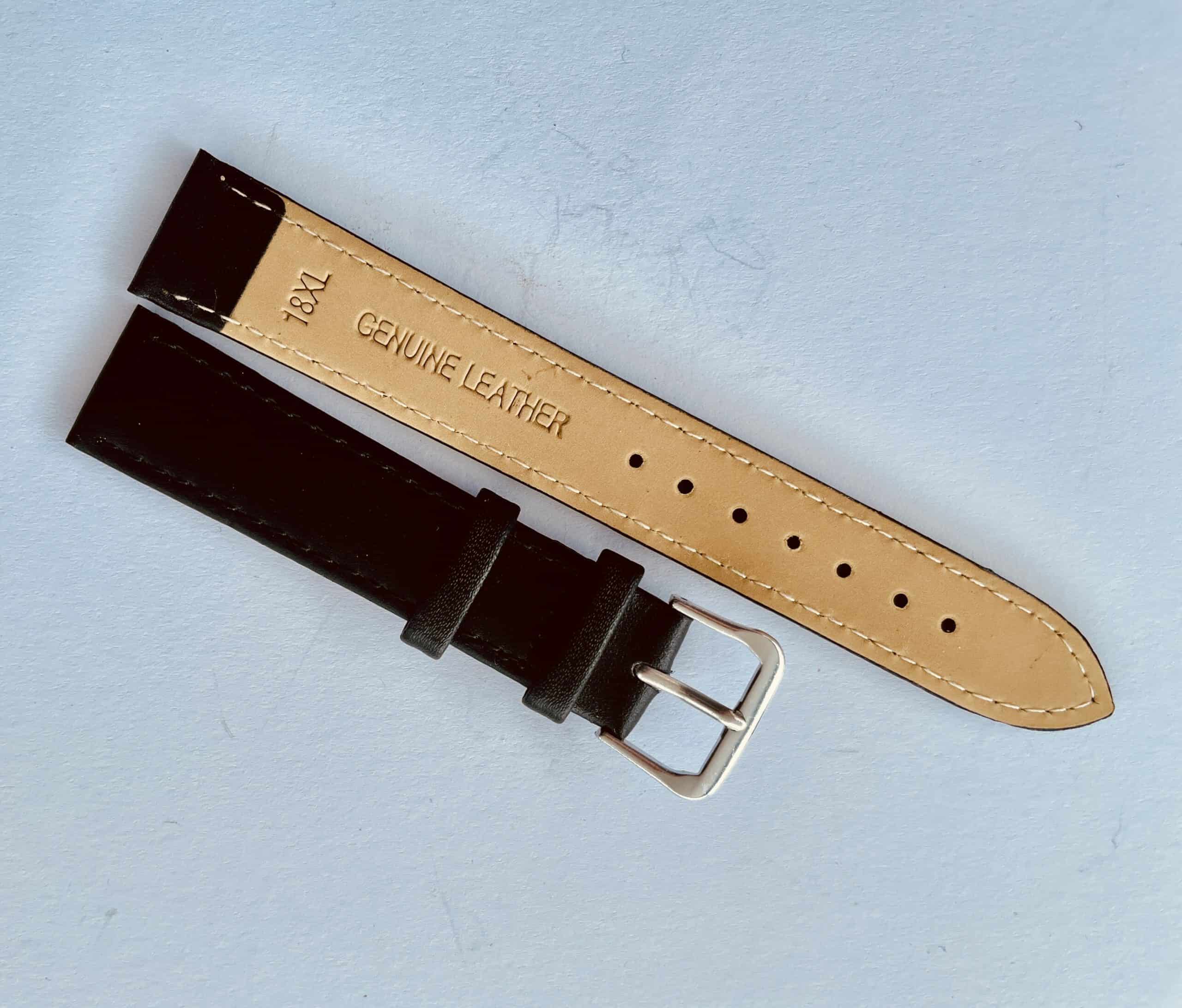 A Genuine Leather Watch Strap 18mm Extra Long (XL) with a gold-coloured buckle is displayed on a light blue surface, showing both front and tan-stamped back ("18XL GENUINE LEATHER").