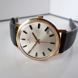 The Zenith 2542C Gold-Plated Mechanical (1968-69), featuring a white dial, black markers, and black leather strap, is shown at 6:20 with a date window at 3 o’clock. Pay with Klarna.