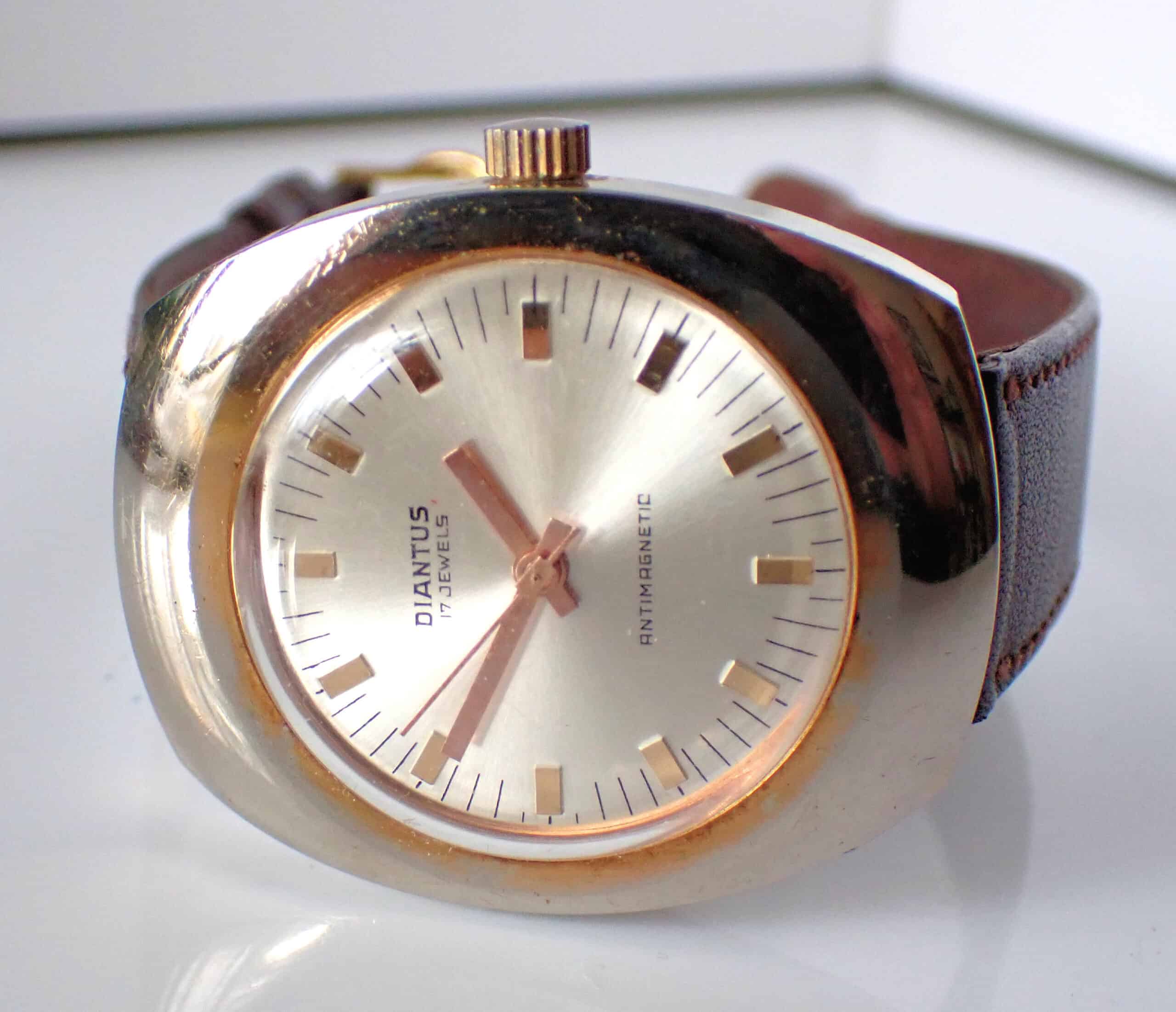 A Diantus 17-Jewel Gold-Tone on Stainless Steel Mechanical Watch, shown on a white surface with gold hour markers and brown leather strap, displays the time as 8:07. Pay interest-free in three with Klarna.