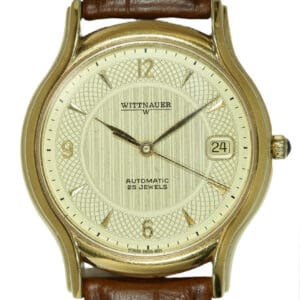 A Wittnauer Automatic Date Watch with original boxes and protective plastic, features a gold case, brown leather strap, cream dial, gold markers, date at 3 o’clock, and “Automatic 25 Jewels” on the face. Pay with Klarna.