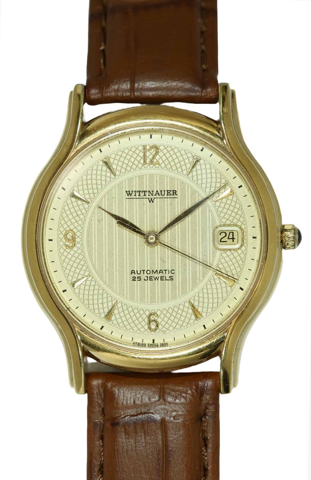 A Wittnauer Automatic Date Watch with original boxes and protective plastic, features a gold case, brown leather strap, cream dial, gold markers, date at 3 o’clock, and “Automatic 25 Jewels” on the face. Pay with Klarna.