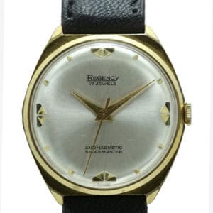 The Regency Deco Style Mechanical Watch features a gold-tone round case, silver dial with gold geometric hour markers, black hands, and a black leather strap. Dial reads "Regency 17 Jewels" and "Antimagnetic Shockmaster." Pay interest-free in three with Klarna.