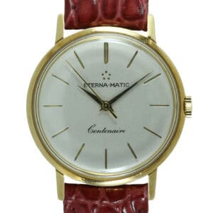 The Eterna-Matic Centenaire Automatic 18ct Solid Gold Watch features a white dial with gold hour markers, minimalistic three-hand design, and a textured burgundy leather strap. Pay interest-free in three with Klarna.