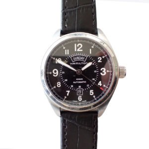 A Hamilton Khaki Field Day Date Auto Automatic 42mm H70505733 wristwatch (£775) with a black dial, silver numerals, day/date display, and black leather strap. The hands point to 10:08. Pay later with Klarna.