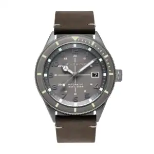 The Spinnaker Cahill Automatic SP-5064-03 features a brown leather strap, grey dial, luminous hour markers, date window at 3 o'clock, and "Automatic 660ft/200m" text above 6 o'clock.