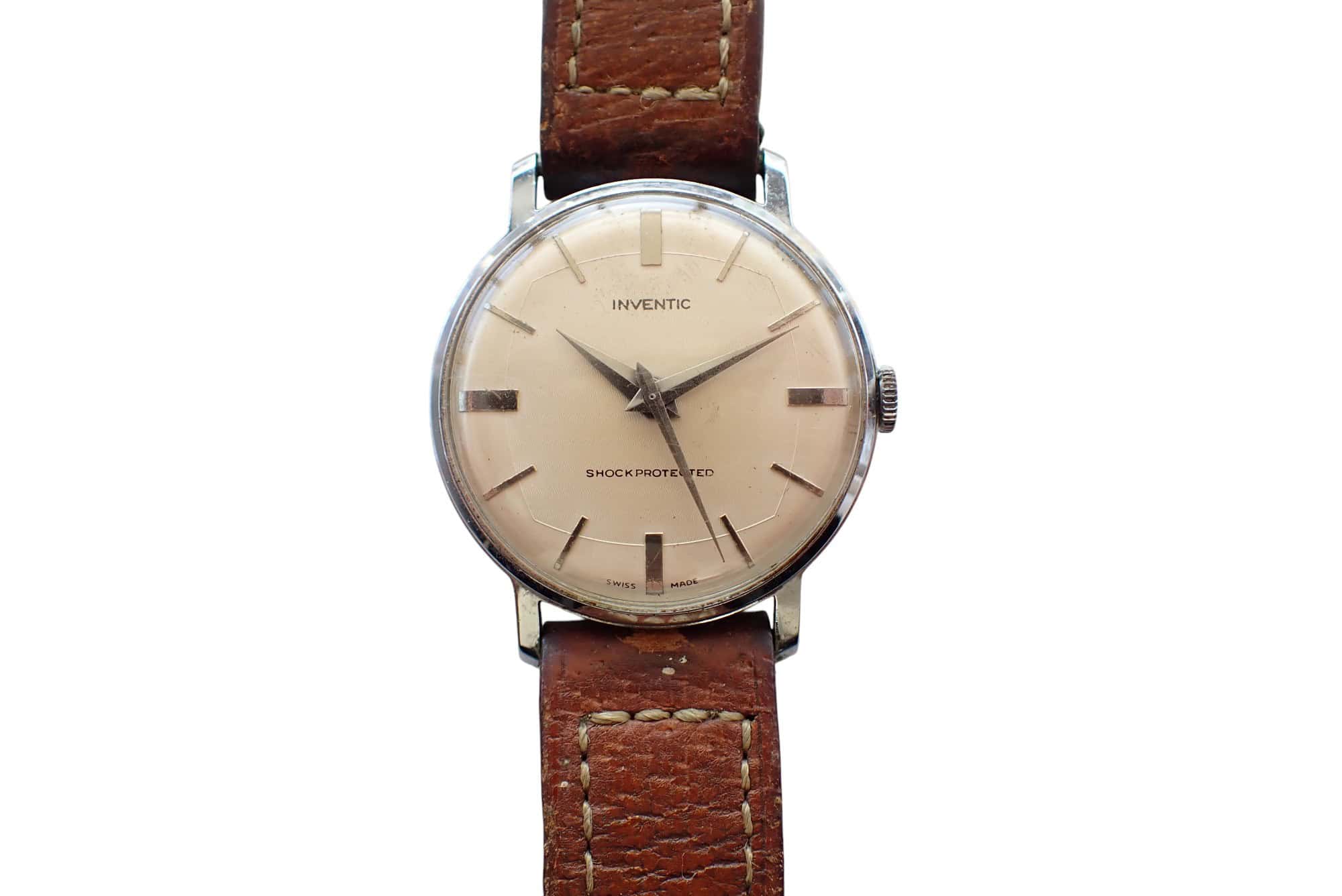 A vintage Inventic Watch c.1950s/60s Deco Style Mechanical with a round beige dial, silver hour markers, and a brown leather strap with visible stitching displays the time as 8:21.