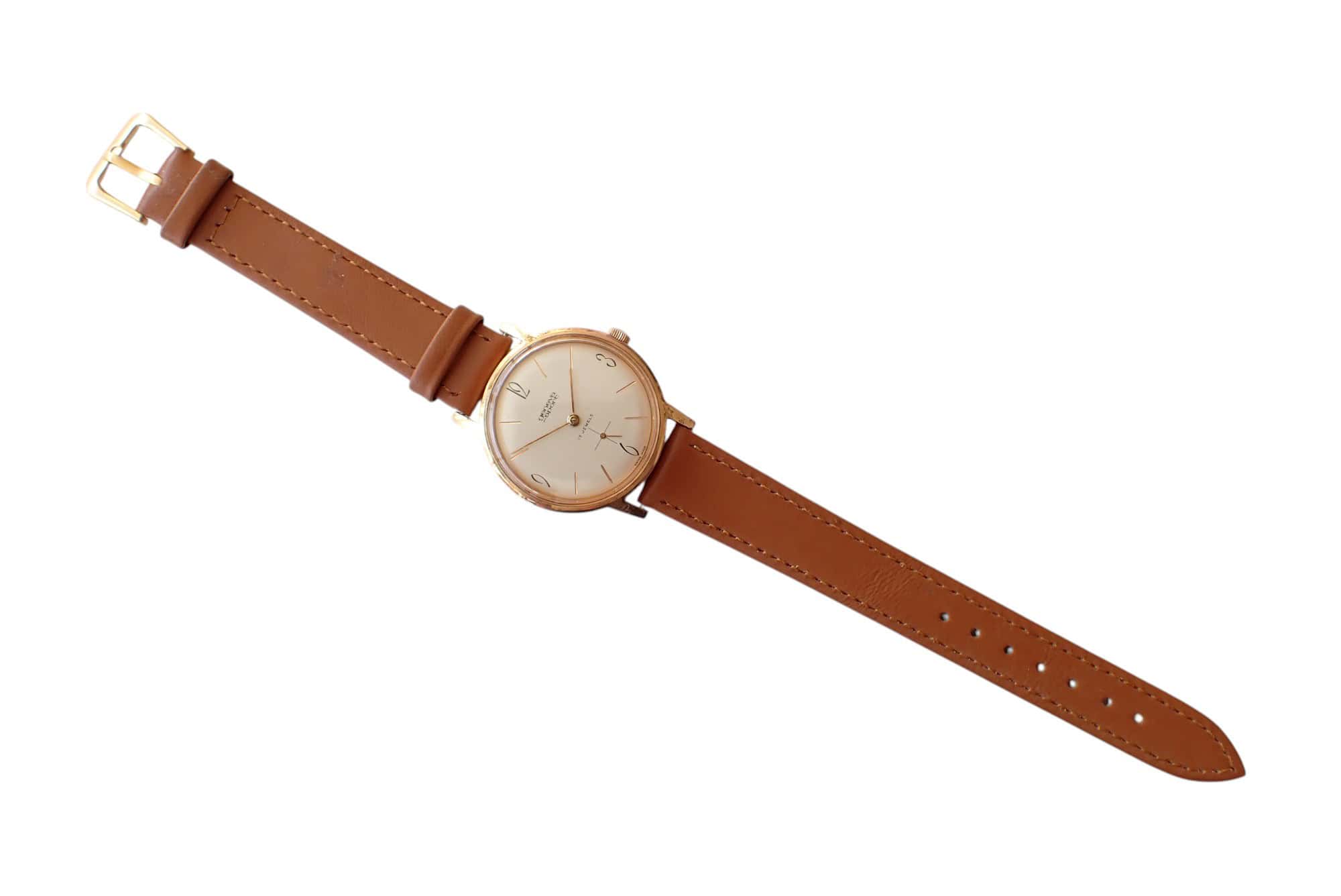 Leather strap watch with gold case and minimalist dial, stylish men's accessory.