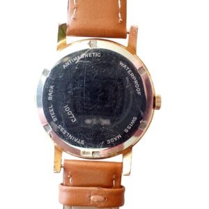 Scratched vintage wristwatch with brown leather strap, waterproof and anti-magnetic features.