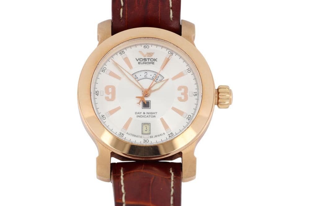 Vostok Europe men's luxury wristwatch with gold-tone case and brown leather strap.