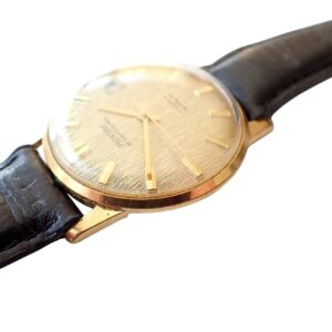 Gold vintage wristwatch with black leather strap, classic analogue design.