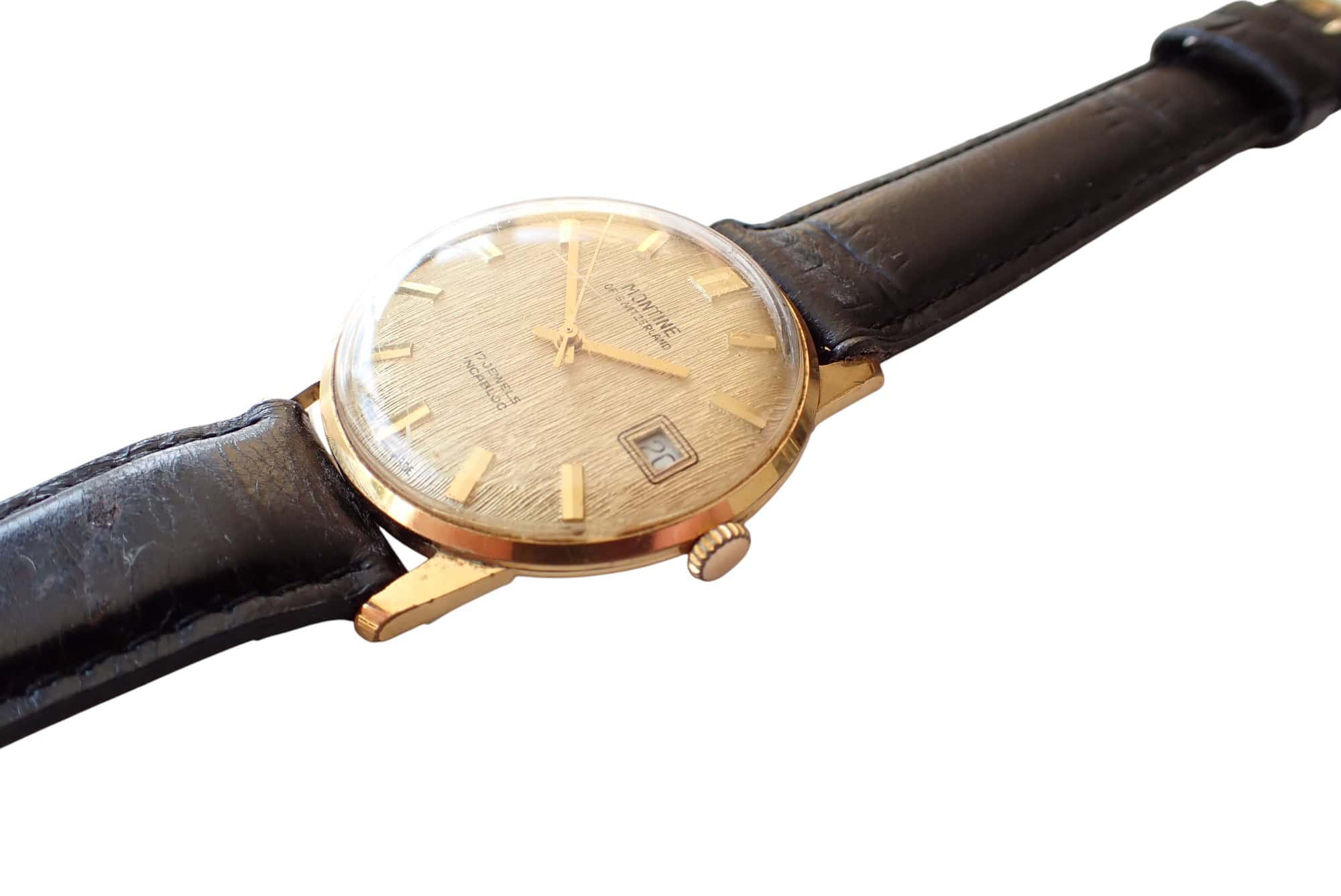 Swiss vintage men's watch with gold case and leather strap, classic luxury timepiece for collectors.