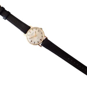 Elegant vintage wristwatch with gold case and black leather strap.