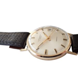 Vintage gold wristwatch with black leather strap, classic design, and date display.