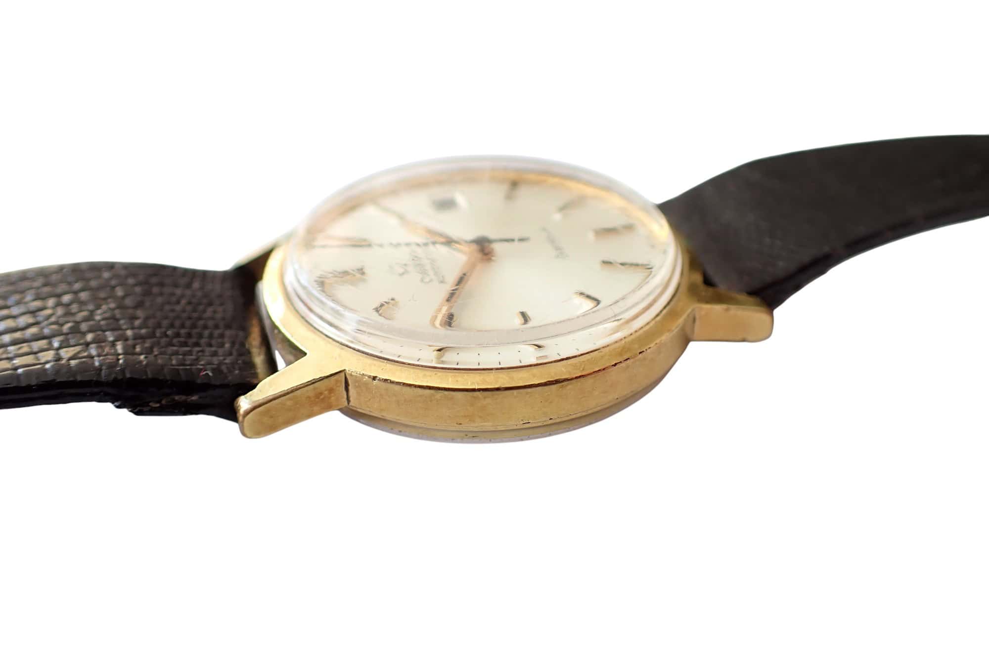 Vintage gold wristwatch with leather strap, classic men's luxury timepiece.