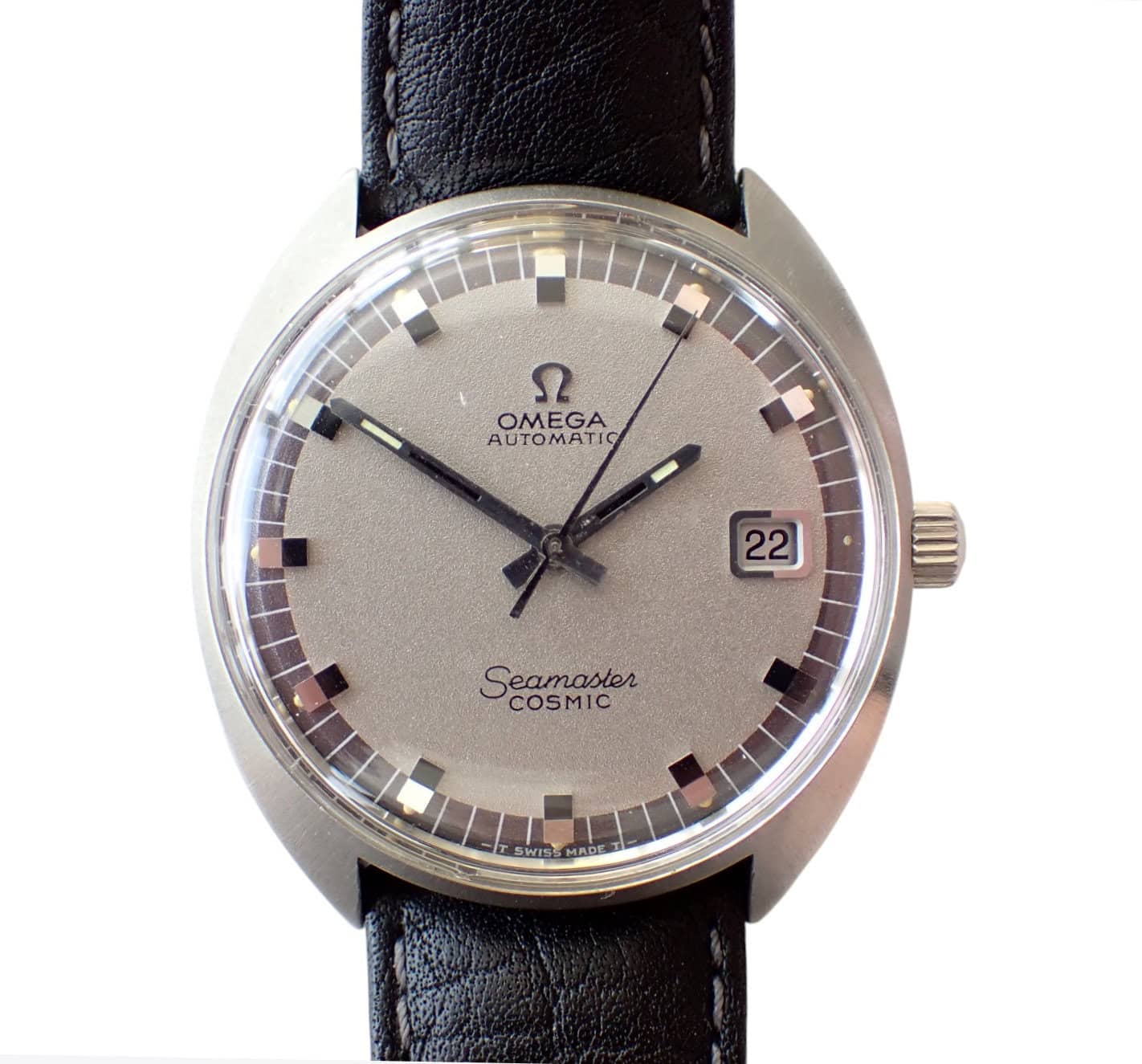 Vintage Omega Seamaster Cosmic watch with a silver dial and black leather strap.