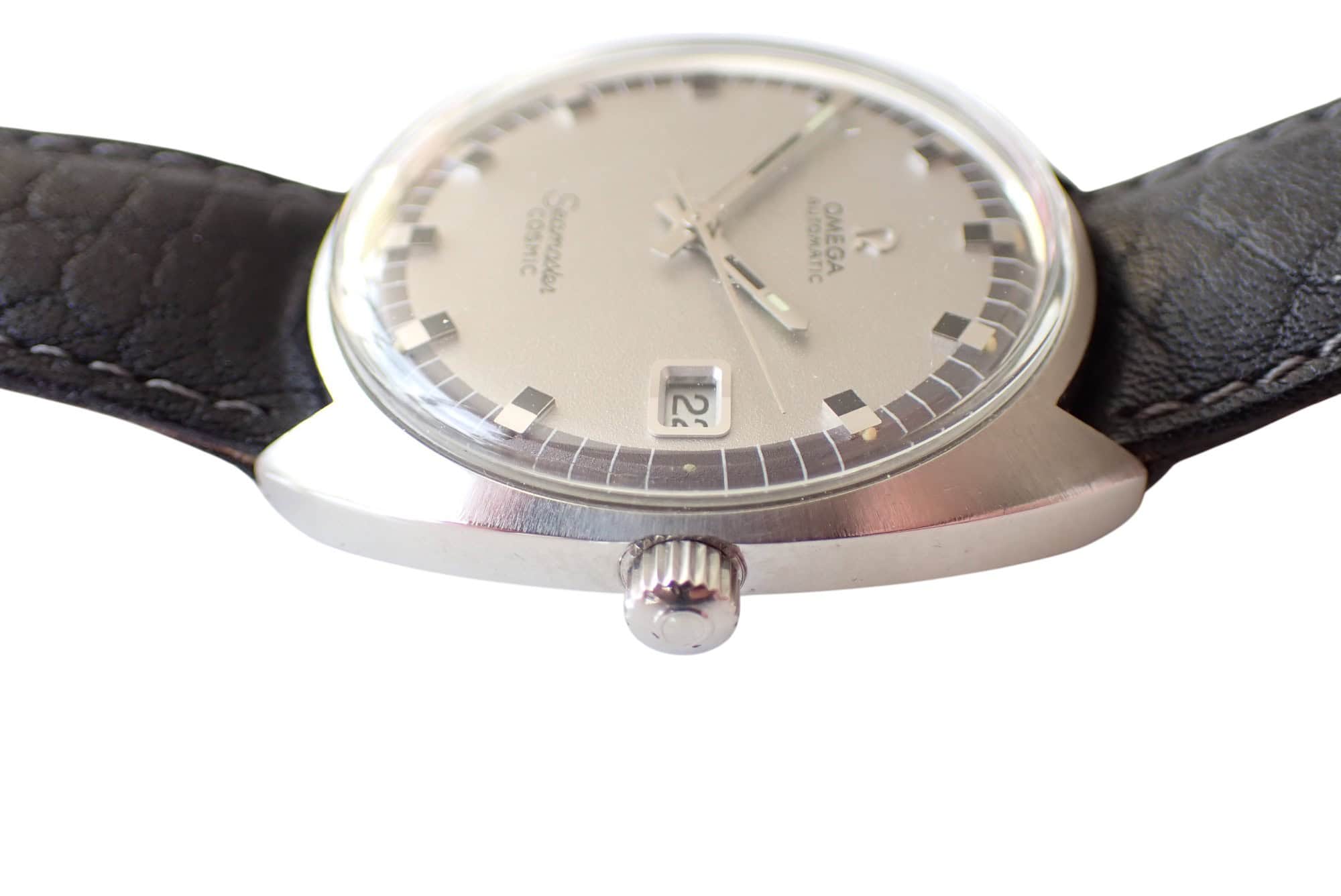 Omega Seamaster vintage wristwatch with silver dial and black leather strap.