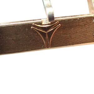 Antique gold buckle of a vintage wristwatch, close-up detail.