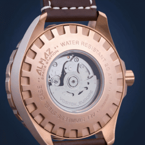 Close-up of the Vostok Europe Almaz Automatic Line NH35A/320B259, featuring a gold-tone stainless steel case, see-through back showing the mechanical movement, and engraved details on water resistance and materials.